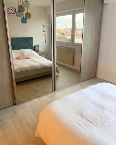 - un miroir dans une chambre avec un lit et un lit dans l'établissement L'Exclusif - Strasbourg, à Strasbourg