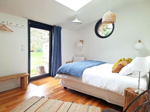 a bedroom with a bed and a large window at Le Clos du Palastre, à 10 mn de Vannes in Plescop
