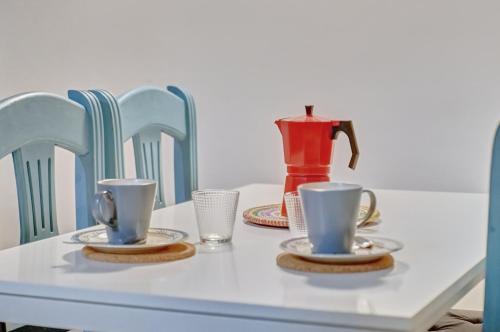 una mesa con dos tazas y platillos y un jarrón en Dormitalería, en Pamplona