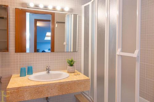 ein Badezimmer mit Waschbecken und Spiegel in der Unterkunft Bleu Soleil By Ericeira Property in Mafra