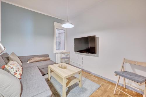 una sala de estar con un sofá y una mesa en Dormitalería, en Pamplona