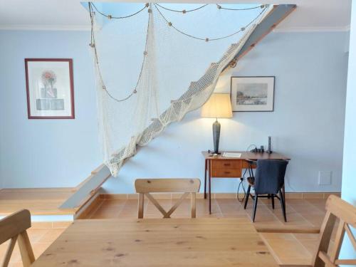 a living room with a staircase and a desk at Bleu Soleil By Ericeira Property in Mafra
