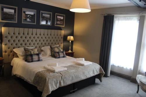 una camera da letto con un letto grande con una grande finestra di Red Dragon Inn a Kirkby Lonsdale