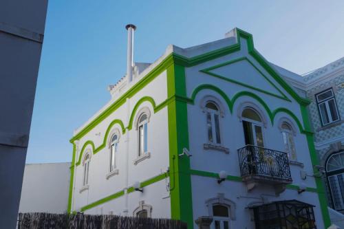 a building with green and white paint on it at White House Lisbon Hostel in Lisbon