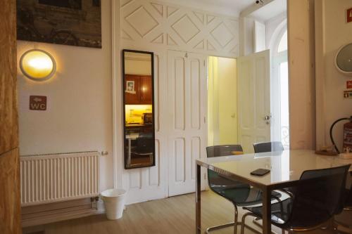 a room with a table and chairs and a mirror at White House Lisbon Hostel in Lisbon