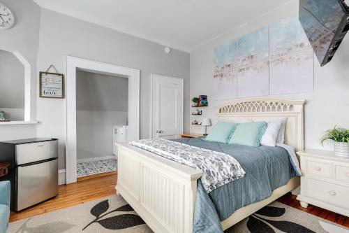 a white bedroom with a bed and a tv at G7 central location museums free parking in Richmond