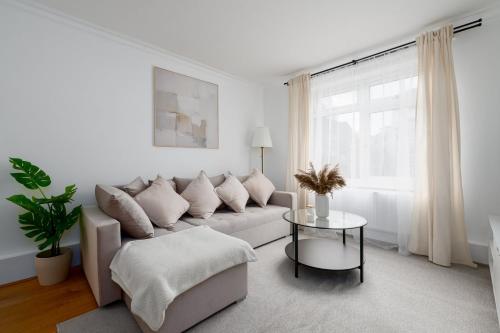a white living room with a couch and a table at GuestReady - Relaxing retreat near Tower Bridge in London