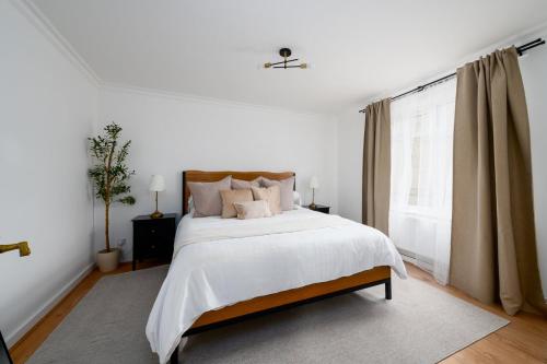 a white bedroom with a large bed and a window at GuestReady - Relaxing retreat near Tower Bridge in London