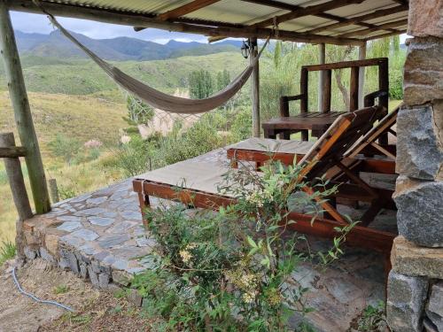 a bed and a hammock in a room with a view at Estancia Altos del Durazno in Estancia Grande