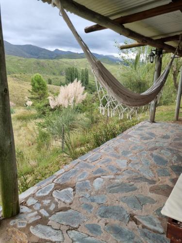 a hammock on a patio with a view of the mountains at Estancia Altos del Durazno in Estancia Grande