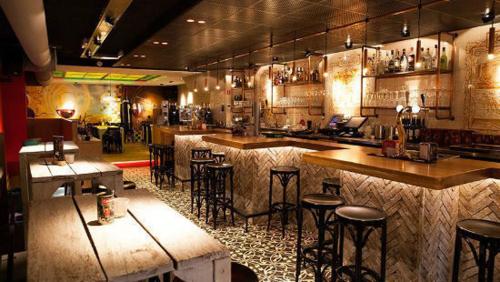 a bar in a restaurant with bar stools at La Casita bed and breakfast in Voorschoten