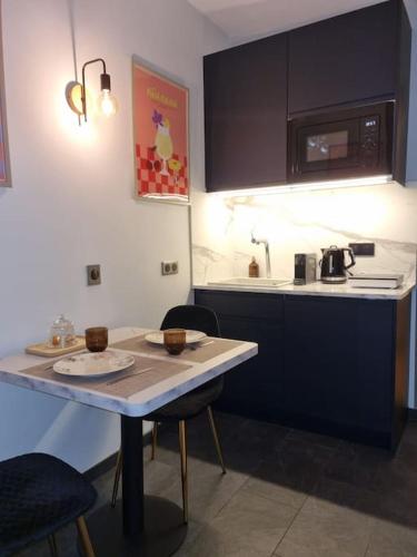 - une petite cuisine avec une table et un comptoir dans l'établissement Studio à 10 minutes de Paris, à Vitry-sur-Seine