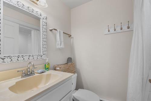 a bathroom with a sink and a toilet and a mirror at Prosecco by Simple Life Rentals in Fish Creek