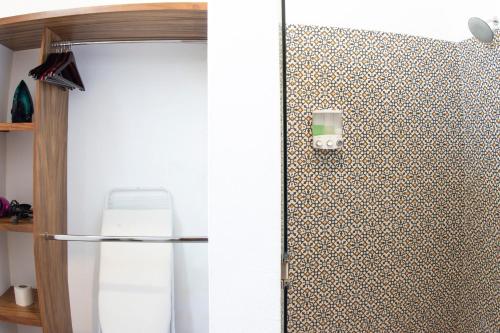 a bathroom with a refrigerator and a wall at Casa Monarcas - Victoria (with AC) in Guadalajara