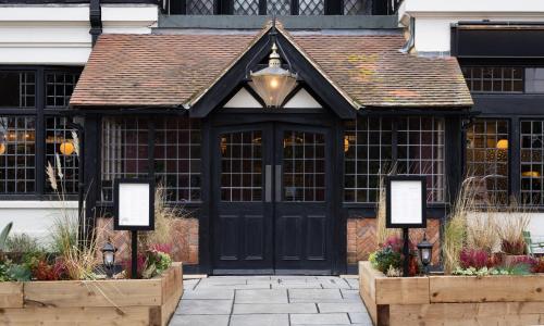 a black front door of a building at The Royal Forest - A Heartwood Inn in Chingford
