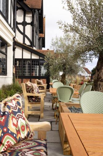 a row of chairs and tables on a patio at The Royal Forest - A Heartwood Inn in Chingford