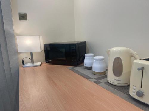 a room with a microwave and a television on a counter at Newly Built Private Ensuite Room in Manchester