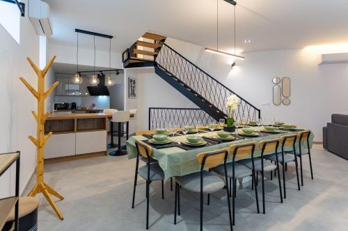 une salle à manger avec une table et des chaises et un escalier dans l'établissement Maison rénovée Climatisée avec Sauna et Baby-Foot, à Strasbourg
