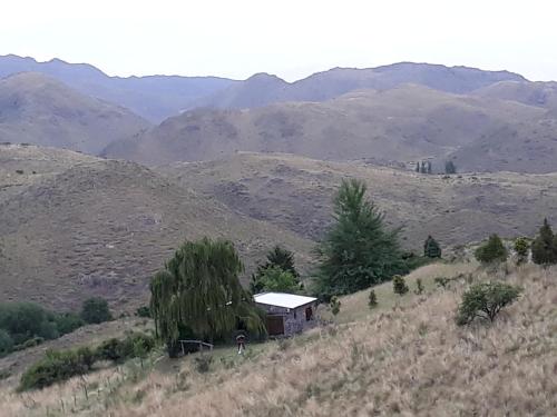 an old house on a hill with mountains in the background at Estancia Altos del Durazno in Estancia Grande