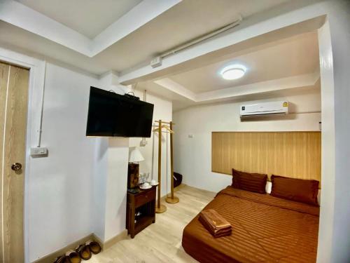 a bedroom with a bed and a flat screen tv at ไร่มีนา ม่อนแจ่ม in Chiang Mai