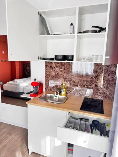a kitchen with white cabinets and a sink at Modern Studio Nr 10 private Kitchenette and Bathroom in Limassol