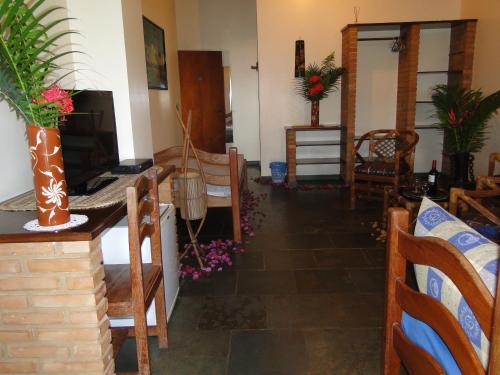 a living room with a table and chairs and a television at Hotel Pousada Arco Iris in Barra de Santo Antônio
