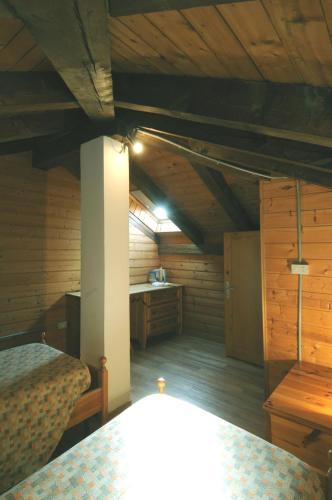 an attic room with two beds and a desk at CASA MOLINI Malé in Malè