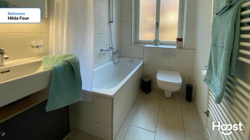 ein Badezimmer mit Badewanne, Toilette und Waschbecken in der Unterkunft H4 Family apartment, central, quite, modern in Zürich