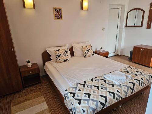 a bedroom with a bed with pillows on it at Cтаи за гости Бърдареви in Bansko
