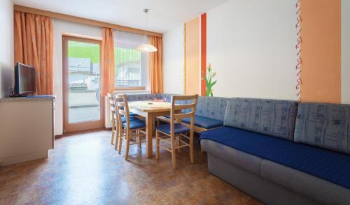 a living room with a couch and a table and chairs at Amtshaus in Tux