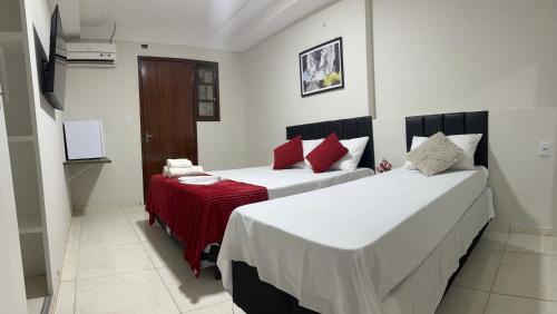 a bedroom with two beds and a red blanket at Pousada - Aconchego do Sol in João Pessoa