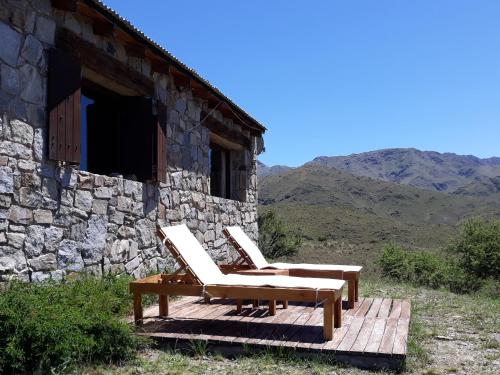 two chairs sitting on a wooden deck outside of a building at Estancia Altos del Durazno in Estancia Grande