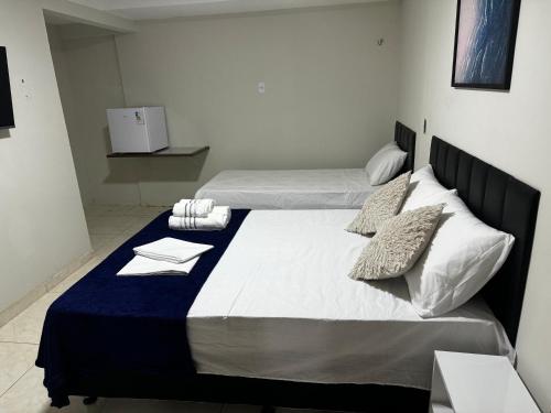 a bedroom with two beds with towels on them at Pousada - Aconchego do Sol in João Pessoa