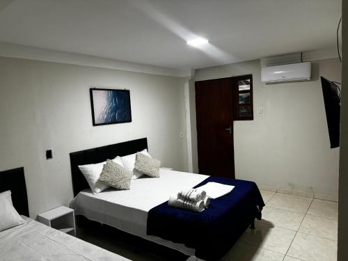 a bedroom with a bed with a blue blanket at Pousada - Aconchego do Sol in João Pessoa