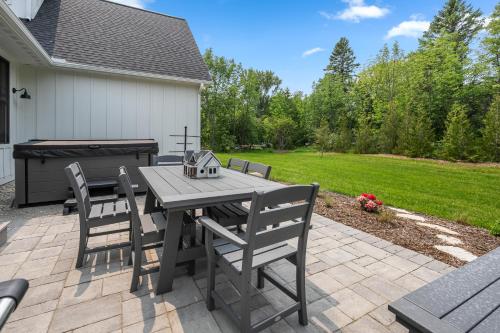 a patio with a table and chairs and a grill at Vita Huset by Simple Life Rentals in Sister Bay