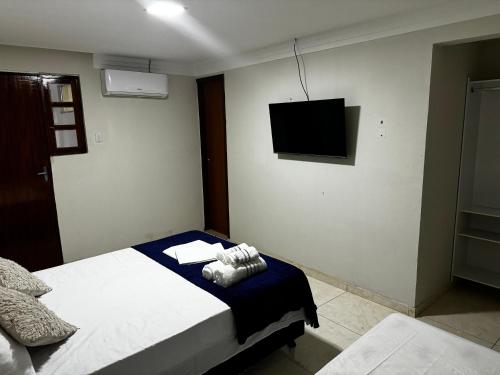 a bedroom with a bed and a flat screen tv at Pousada - Aconchego do Sol in João Pessoa