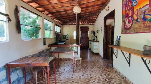 a room with benches and tables in a house at Bela Oyá Casa Hostel in Vale do Capao