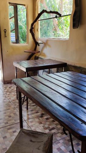 two wooden benches in a room with two windows at Bela Oyá Casa Hostel in Vale do Capao