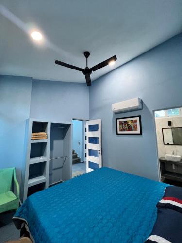 a bedroom with a bed and a ceiling fan at Casa Cristina Mamá Regañona in Bahías de Huatulco