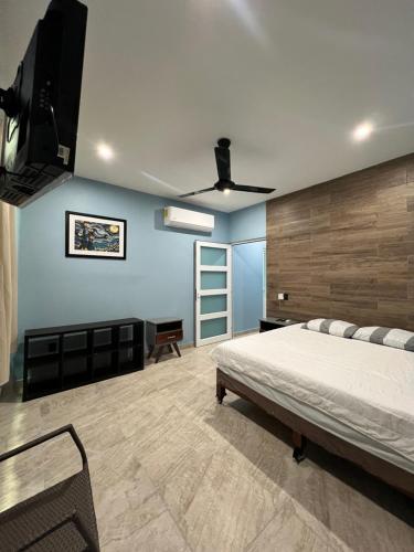 a bedroom with a bed and a tv on the wall at Casa Cristina Mamá Regañona in Bahías de Huatulco
