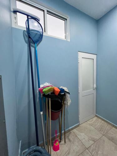 a room with a blue wall with a mop at Casa Cristina Mamá Regañona in Bahías de Huatulco