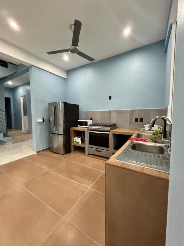 a large kitchen with a sink and a refrigerator at Casa Cristina Mamá Regañona in Bahías de Huatulco