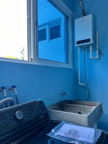 a blue bathroom with a sink and a mirror at Casa Cristina Mamá Regañona in Bahías de Huatulco