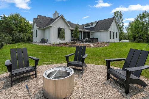 two chairs and a fire pit in front of a house at Vita Huset by Simple Life Rentals in Sister Bay