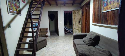 a living room with a staircase and a couch at Bela Oyá Casa Hostel in Vale do Capao