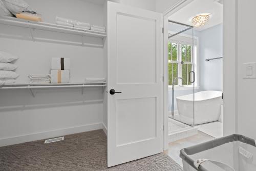 a bathroom with a white door leading to a tub at Vita Huset by Simple Life Rentals in Sister Bay