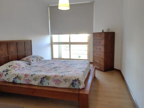 a bedroom with a bed and a window and a dresser at esposendebeachapartment in Esposende