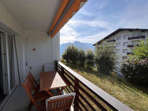 a balcony with a table and chairs and a view at Charmant appart, avec parking à quelques minutes du départ des télécabines in Crans-Montana