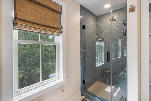 a bathroom with a shower and a window at Vita Huset by Simple Life Rentals in Sister Bay