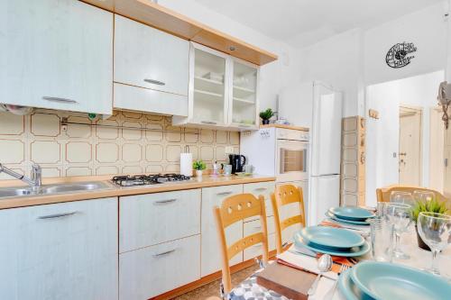 a kitchen with white cabinets and a table with plates at 15min Malpensa - Casa x4 con self check-in in Busto Arsizio